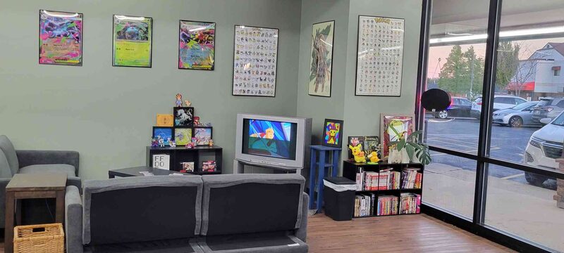 The lounge, with couches, a television and shelves of manga